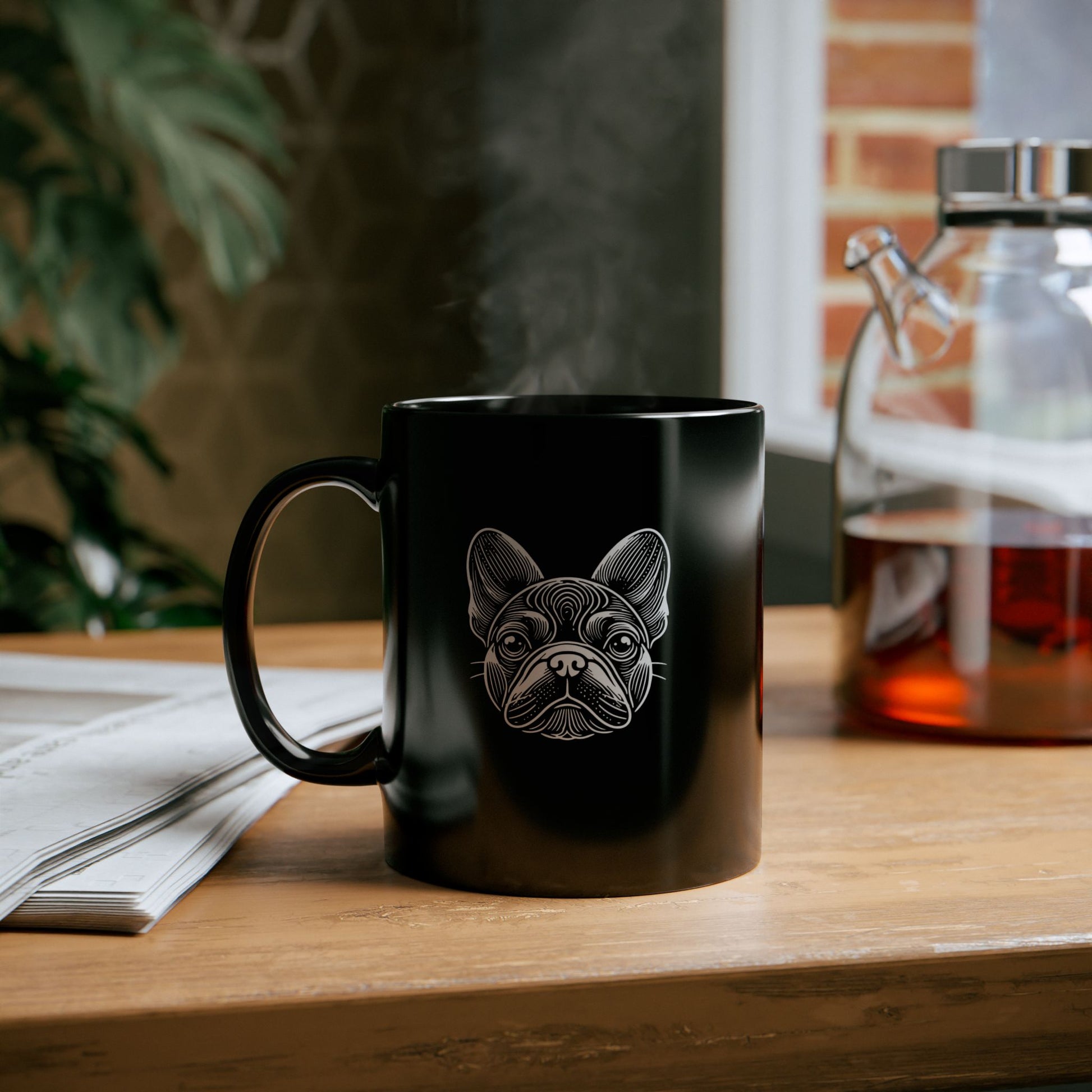 Black ceramic mug with white woodcut portrait of a French Bulldog  on wood counter
